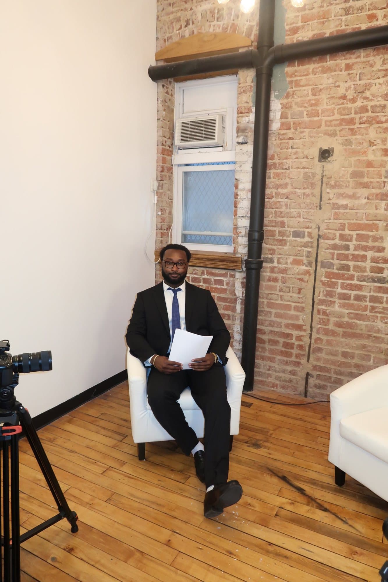 Brian L. Allen seated on his interview set, reviewing notes